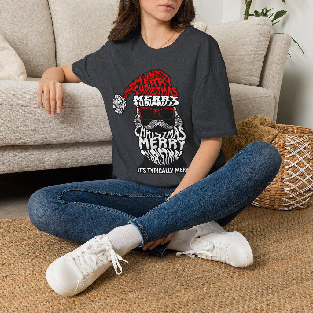 Cool Santa Sunglasses Typography Merry t-shirt in Dark Heather Grey, worn by a woman seated on a rug