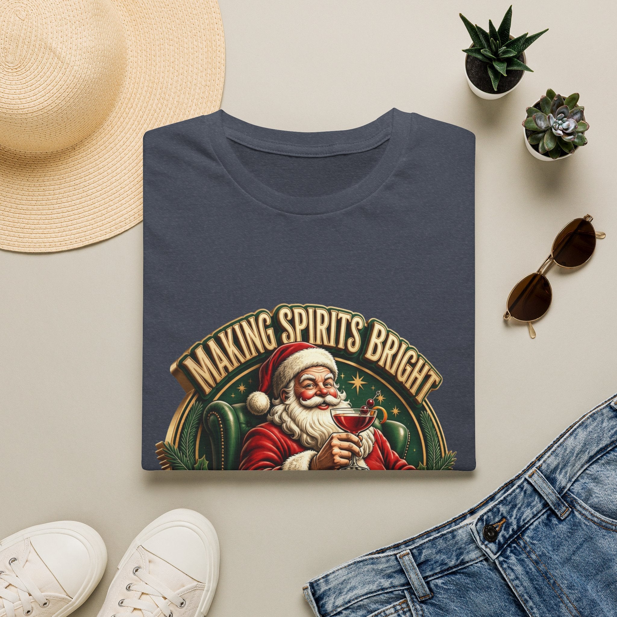Making Spirits Bright and Stronger Santa print on a Heather Navy t-shirt, folded beside a straw hat and jeans