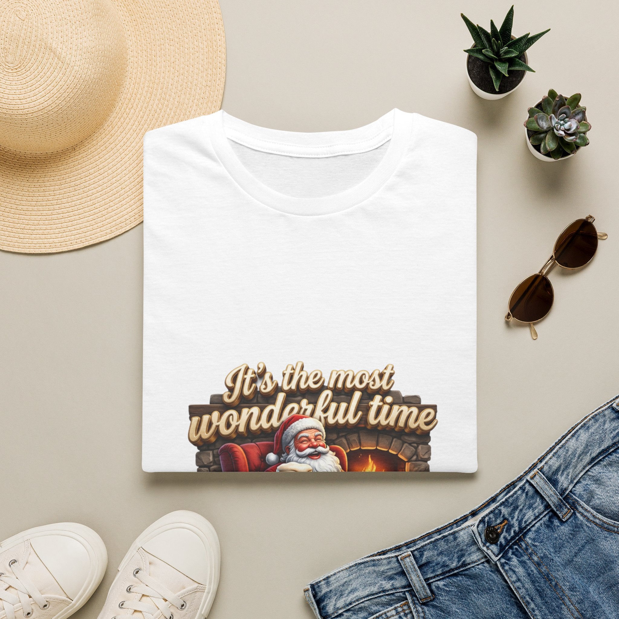 Most Wonderful Time for a Beer Santa print on a White t-shirt, folded beside a straw hat and jeans