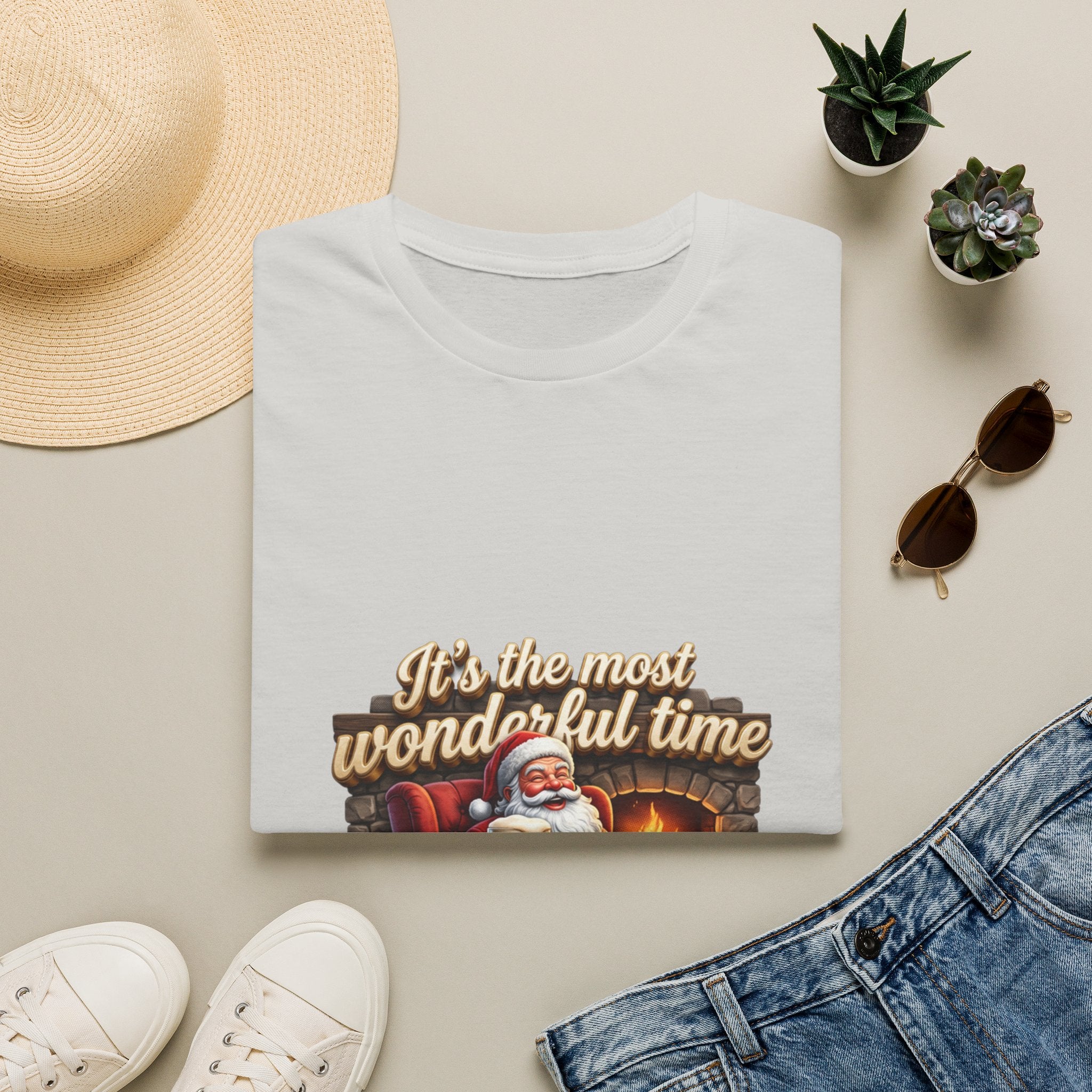 Most Wonderful Time for a Beer Santa print on an Ice Grey t-shirt, folded beside a straw hat and jeans