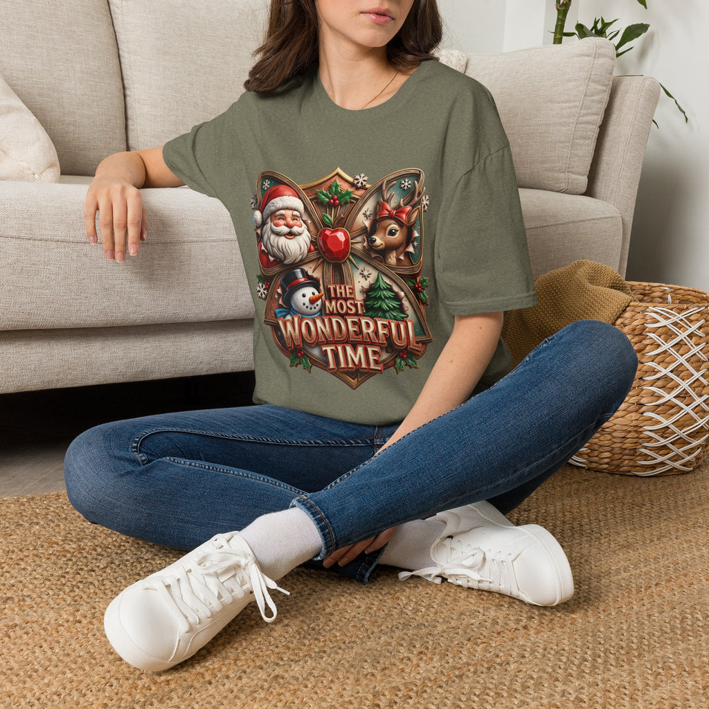 The Most Wonderful Time Wood Crest Santa t-shirt in Heather Military Green, worn by a woman seated on a rug