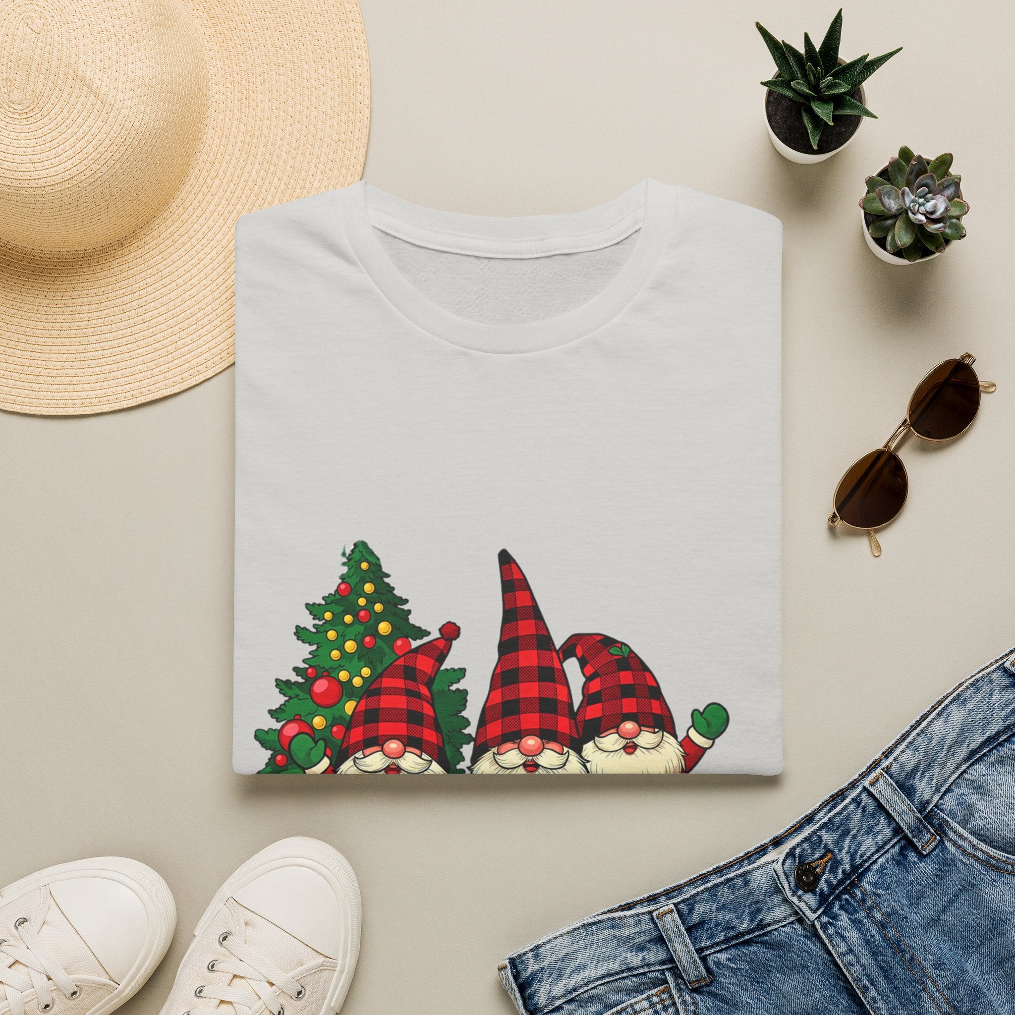 Buffalo Plaid Gnomes Red Truck print on an Ice Grey t-shirt, folded beside a straw hat and jeans