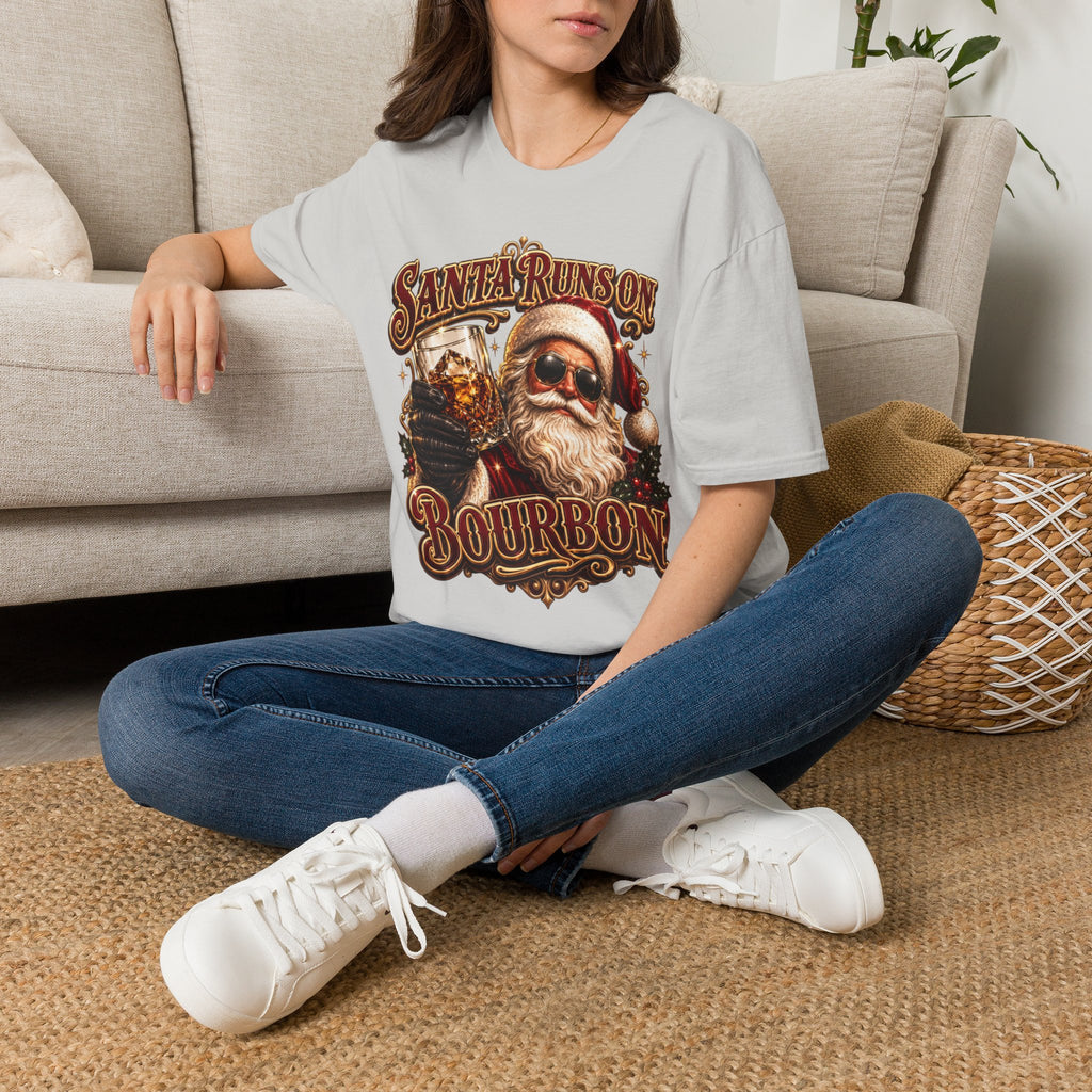 Santa Runs on Bourbon Vintage Whiskey t-shirt in Ice Grey, worn by a woman seated on a rug