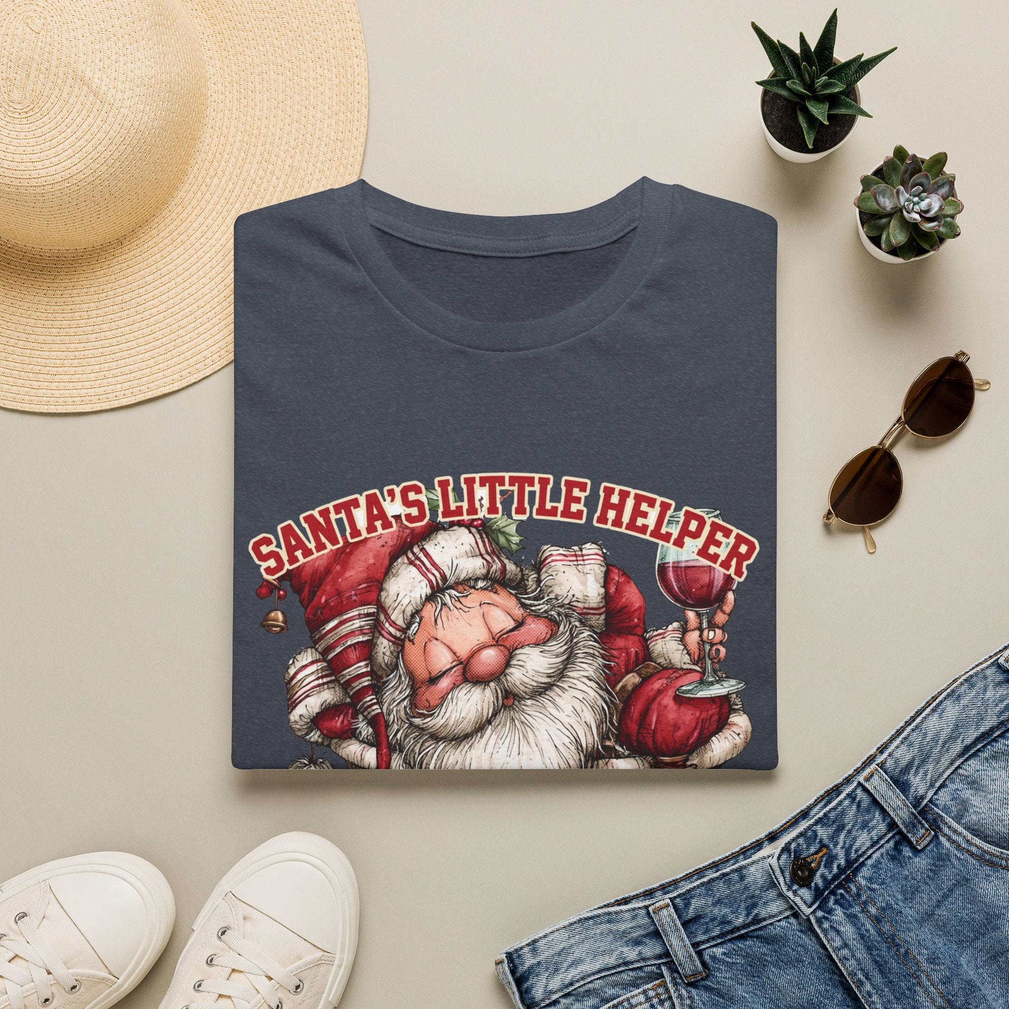 Santa's Little Helper Is Lit Christmas Wine print on a Heather Navy t-shirt, folded beside a straw hat and jeans