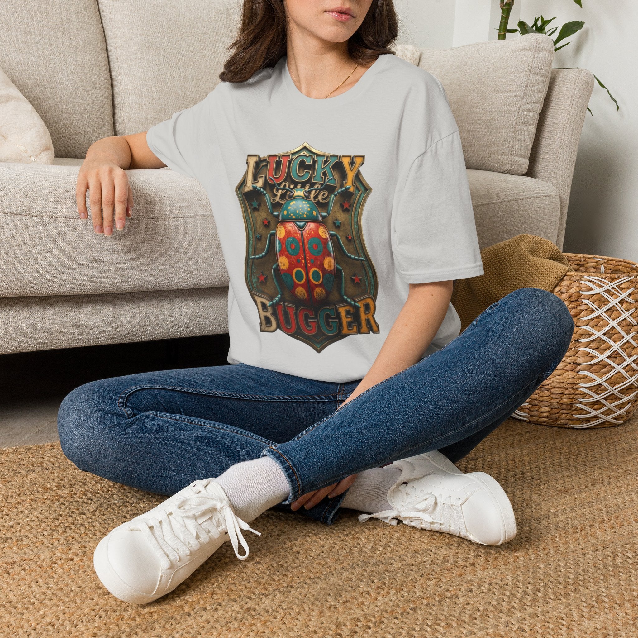 Lucky Little Bugger Vintage Beetle t-shirt in Ice Grey, worn by a woman seated on a rug