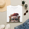 Dear Santa I Can Explain Sunglasses Crest print on a White t-shirt, folded beside a straw hat and jeans