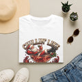 Chillin' Like a Kringle Santa print on a White t-shirt, folded beside a straw hat and jeans