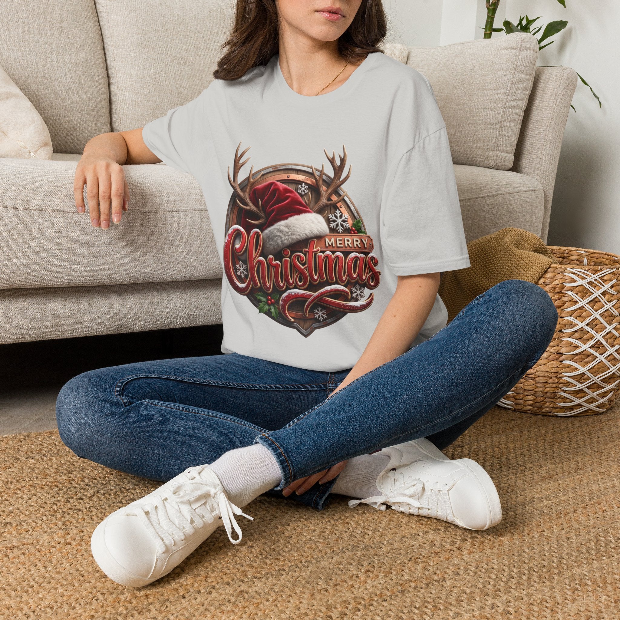Merry Christmas Vintage Santa Hat & Antlers t-shirt in Ice Grey, worn by a woman seated on a rug