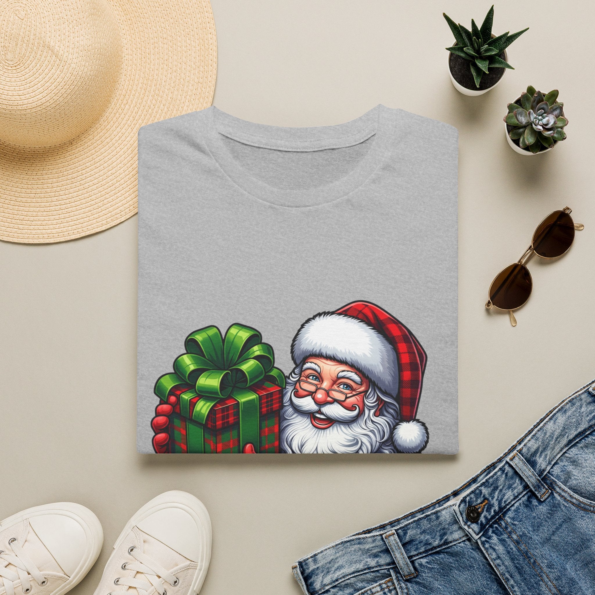 Santa Have a Plaid-astic print on a Sport Grey t-shirt, folded beside a straw hat and jeans