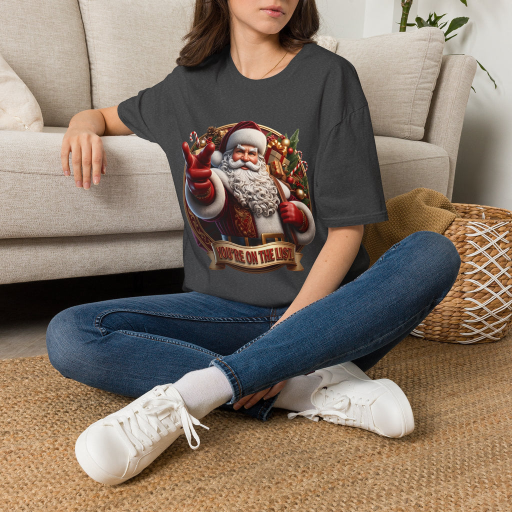 Santa You're On The List Pointing t-shirt in Dark Heather, worn by a woman seated on a rug