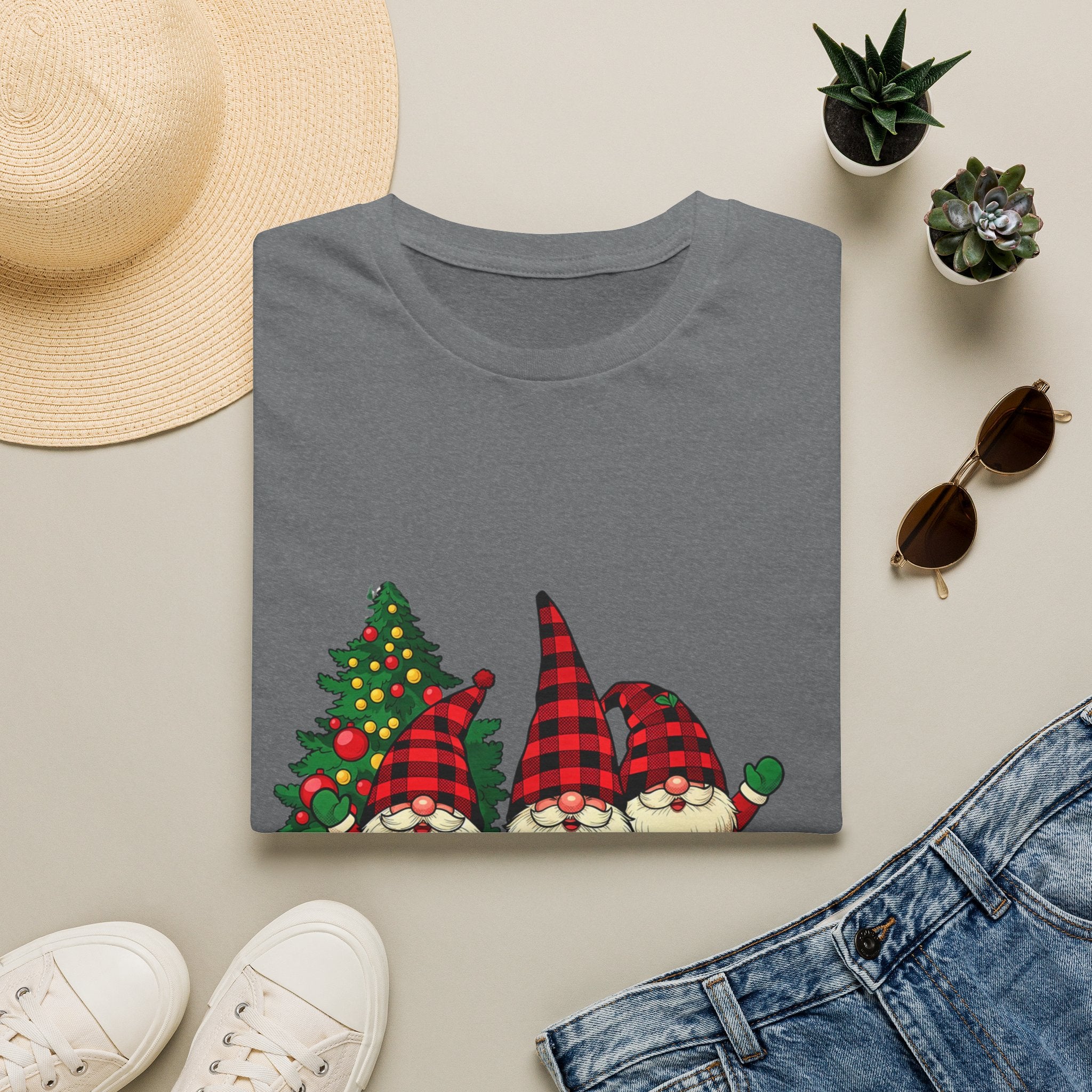 Buffalo Plaid Gnomes Red Truck print on a Graphite Heather t-shirt, folded beside a straw hat and jeans