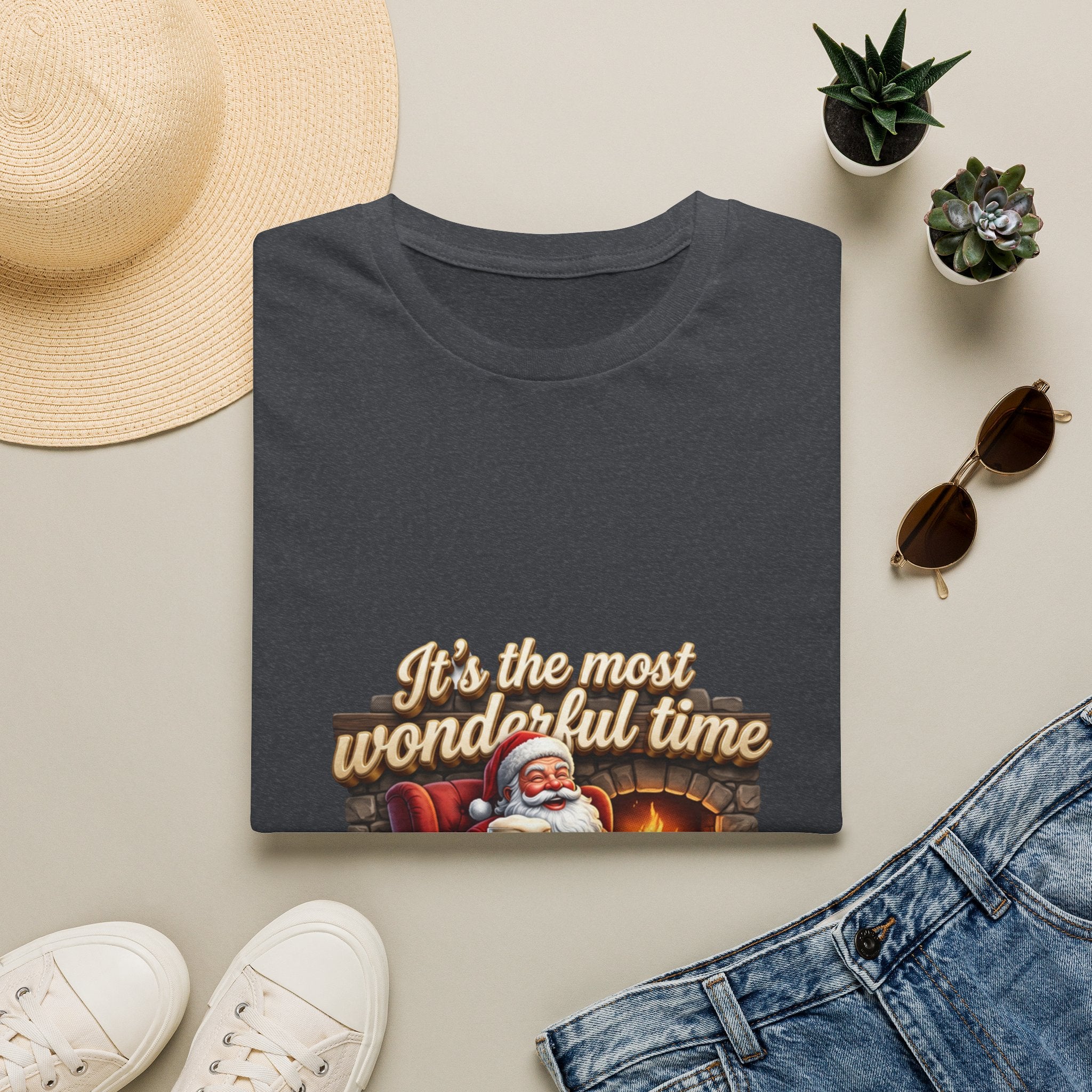 Most Wonderful Time for a Beer Santa print on a Dark Heather Grey t-shirt, folded beside a straw hat and jeans