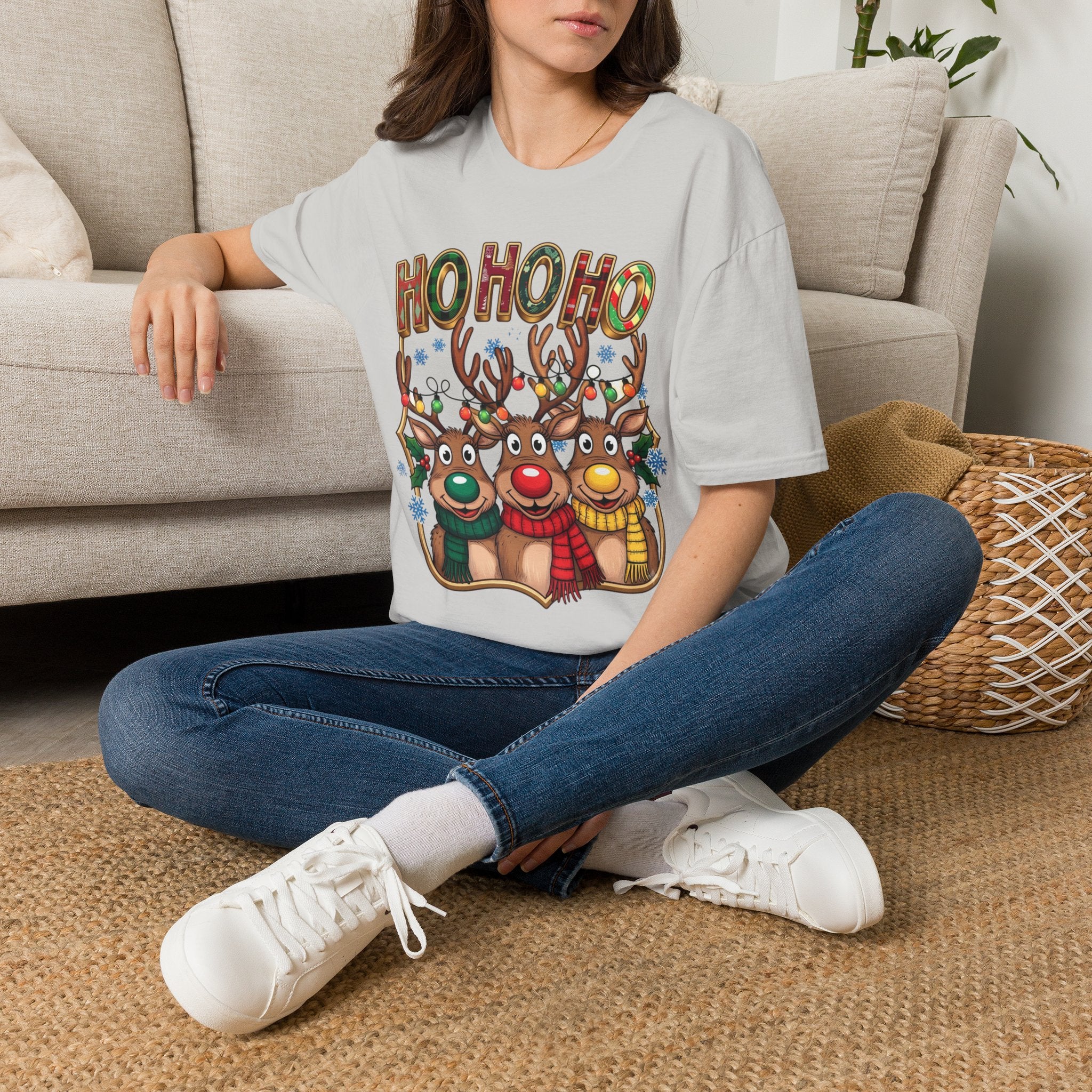 Reindeer Trio Ho Ho Ho Christmas Lights t-shirt in Ice Grey, worn by a woman seated on a rug