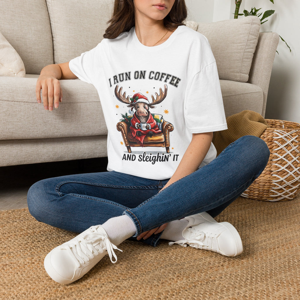 Moose I Run On Coffee and Sleighin' It t-shirt in White, worn by a woman seated on a rug