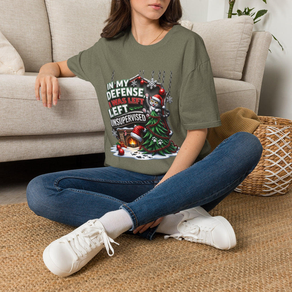 Cat In My Defense Left Unsupervised t-shirt in Heather Military Green, worn by a woman seated on a rug