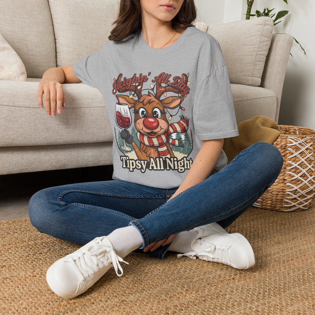 Reindeer Sleighin' All Day Tipsy All Night t-shirt in Sport Grey, worn by a woman seated on a rug