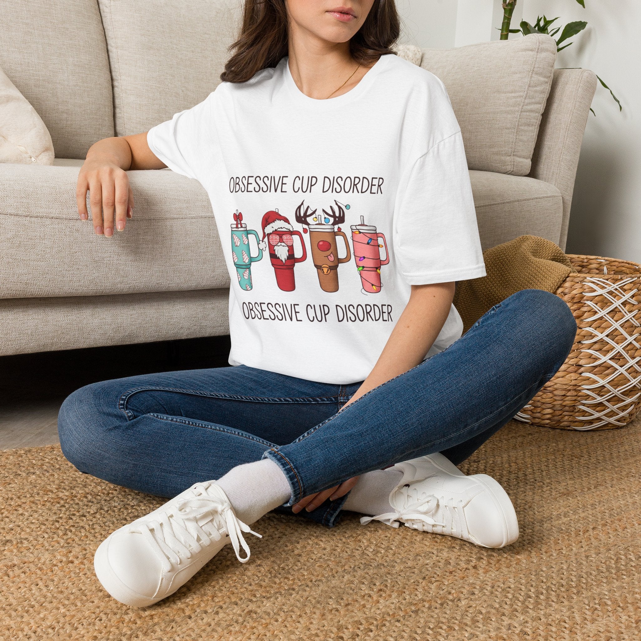 Obsessive Cup Disorder Funny Christmas Tumbler t-shirt in White, worn by a woman seated on a rug