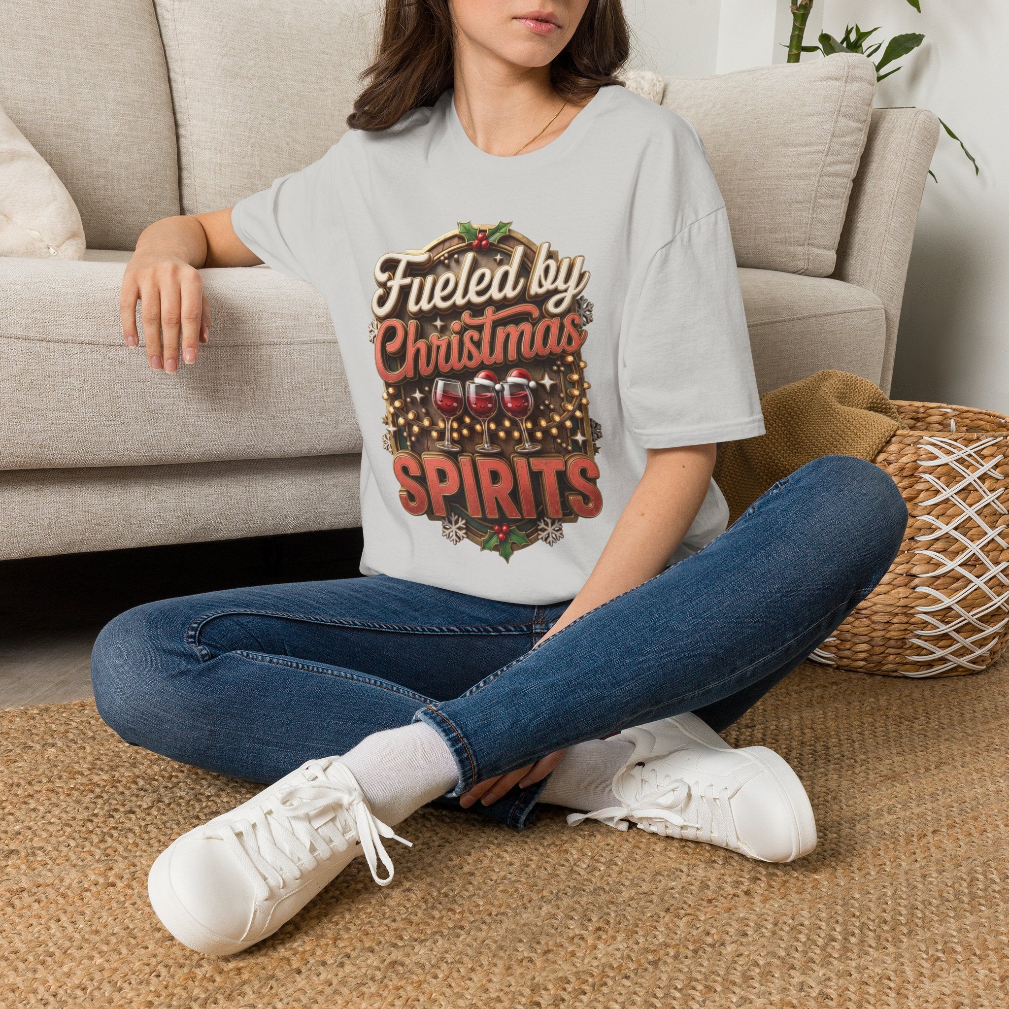 Fueled by Christmas Spirits Wine t-shirt in Ice Grey, worn by a woman seated on a rug