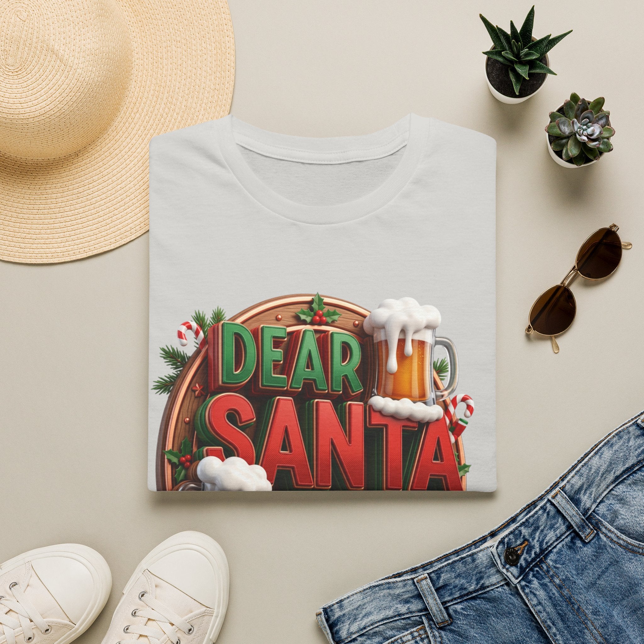 Dear Santa Just Bring Beer Funny print on an Ice Grey t-shirt, folded beside a straw hat and jeans