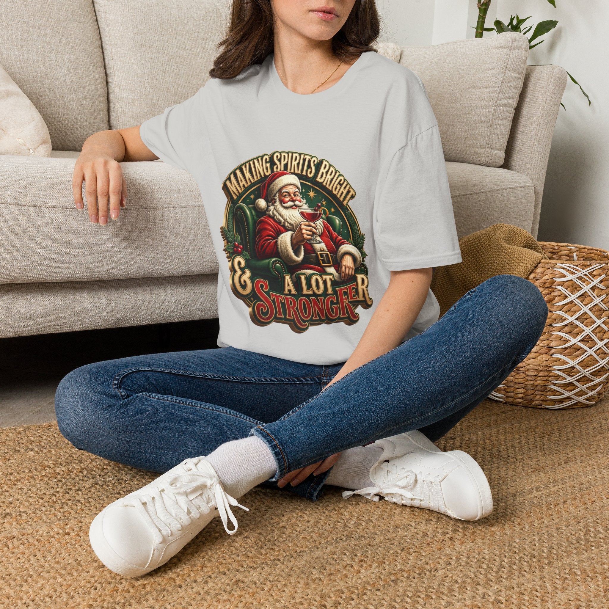 Making Spirits Bright and Stronger Santa t-shirt in Ice Grey, worn by a woman seated on a rug